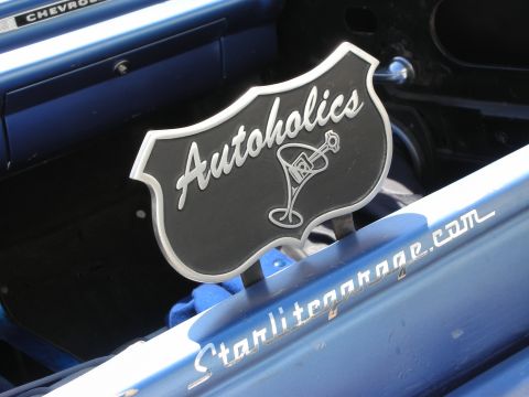 1998 Ford Crown Victoria - chrome-edged Autoholics car-club plaque with a martini-glass logo mounted on a blue vehicle reading Starlitegarage.com.