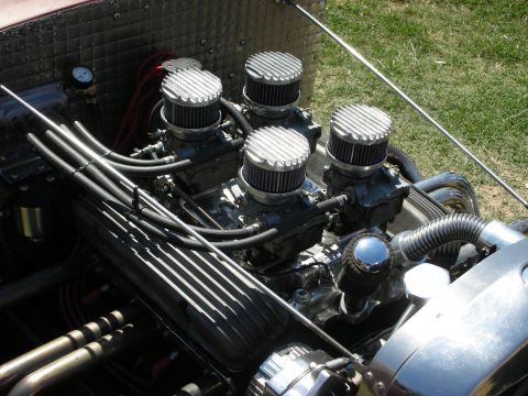 1998 Ford Crown Victoria - Overhead view of a hot rod V8 engine topped with four finned chrome air cleaners over multiple carburetors and braided fuel lines.