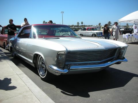 1998 Ford Crown Victoria - Front three-quarter view of a silver 1960s personal-luxury coupe with a wide horizontal-bar grille and clamshell headlight covers.
