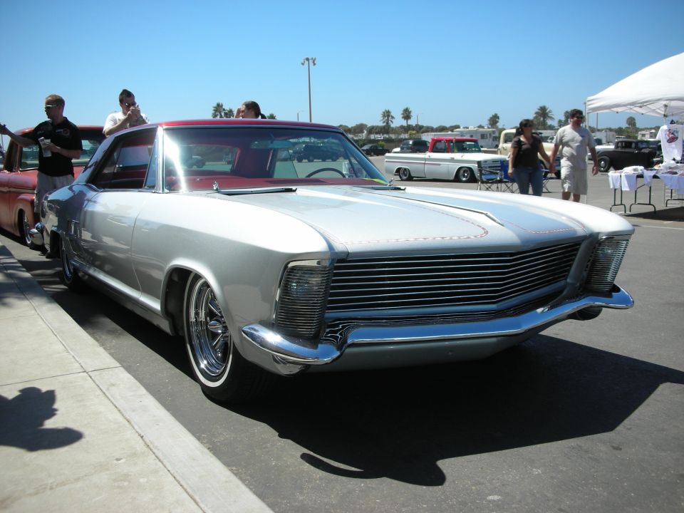 Front of silver 1960s coupe with horizontal-bar grille and hidden headlights
