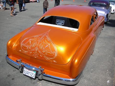 1998 Ford Crown Victoria - Rear view of a copper-orange chopped custom coupe with elaborate white pinstriping on the trunk and a California plate reading 5SQY723.