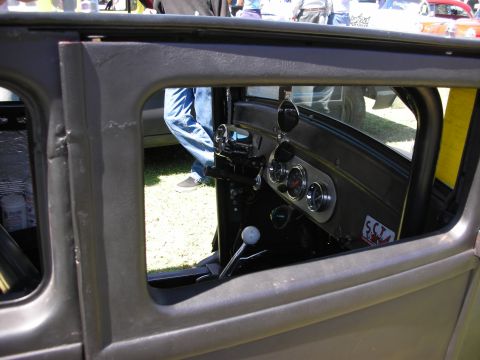 1998 Ford Crown Victoria - View through a hot rod's open window of a body-colored dash with round gauges and a white-knobbed floor shifter.