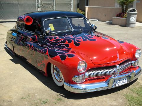 1998 Ford Crown Victoria - chopped and lowered custom coupe in red with black flames, wide chrome grille, whitewalls and a HERCULA plate.