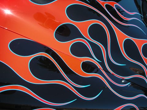 1998 Ford Crown Victoria - Detailed view of a black car surface covered in orange flames outlined in bright blue.