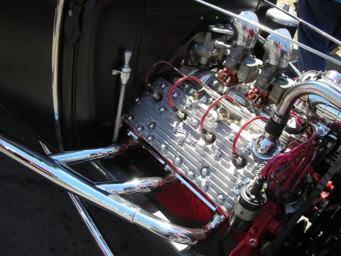 1998 Ford Crown Victoria - Top-down view of a polished aluminum finned engine with red spark-plug wires and chrome details in an engine bay.
