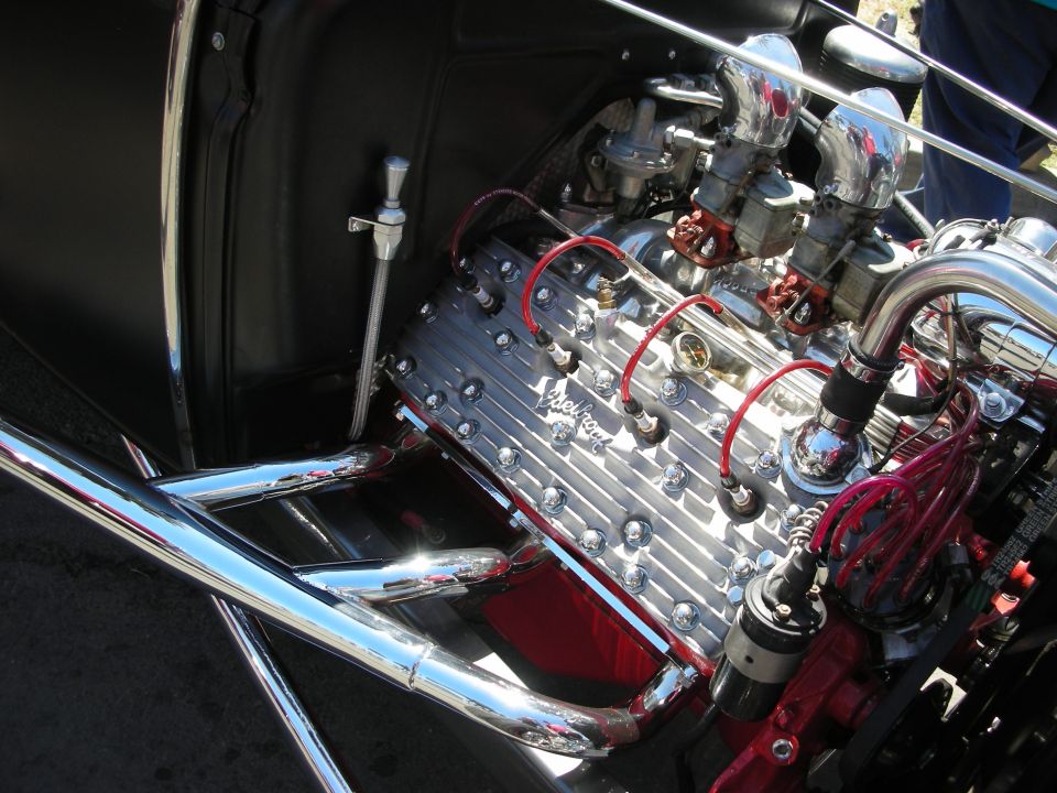 Polished finned engine with red plug wires mounted in an engine bay