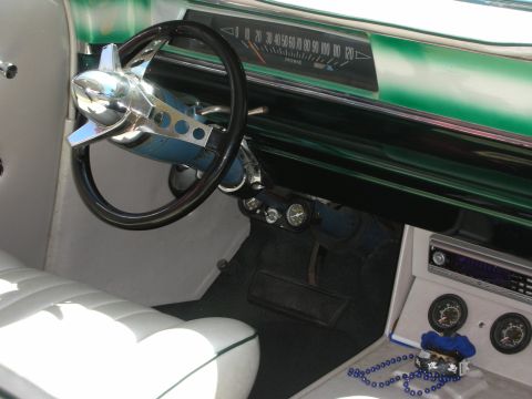 1998 Ford Crown Victoria - Interior of a customized classic car showing a teal metalflake painted dashboard, chrome accented steering wheel and white tuck-and-roll se…