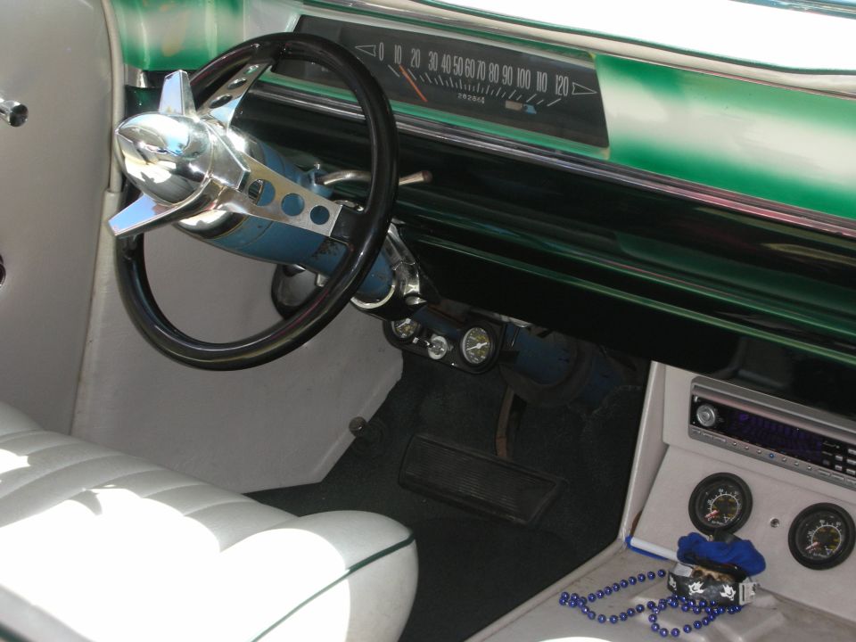Custom car interior with teal metallic dash and chrome bullet-tip steering wheel