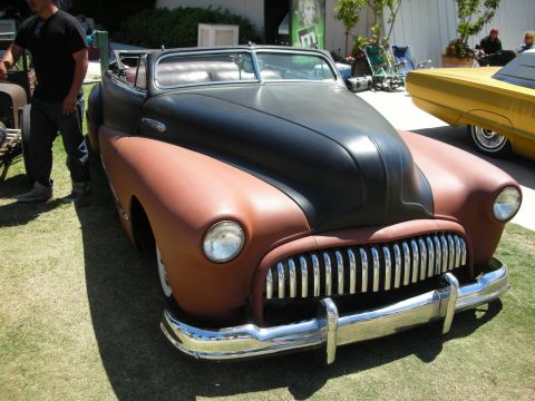 1998 Ford Crown Victoria - chopped late-1940s style custom coupe with a black roof over rust-brown body, vertical-bar grille and a man standing alongside at a show.