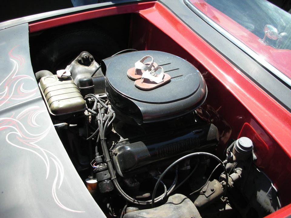 V8 engine bay of a red custom car with flame-pinstriped inner fender