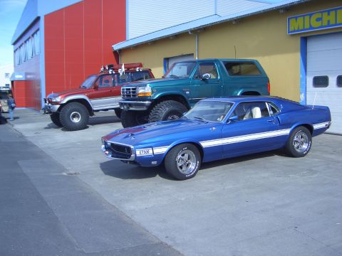 1996 Ford Bronco - A blue 1969 Shelby GT500 sits in front of a green Ford Bronco and a red off-road SUV.