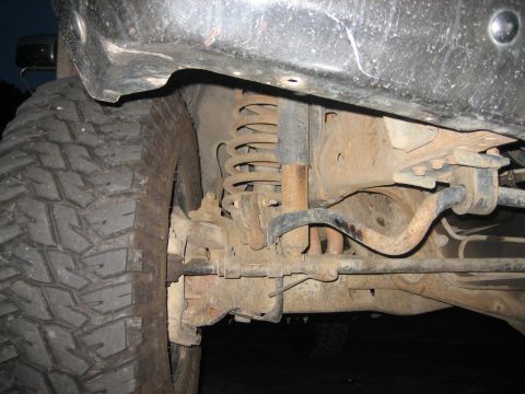 1990 Ford Bronco - This image shows the suspension components and a large tire of an off-road vehicle.