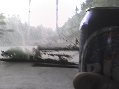 1984 Ford Bronco - A soda can obscures the view of a hazy outdoor landscape with trees and foliage.