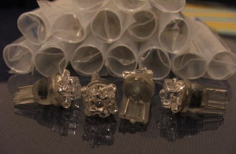 1985 Ford LTD Crown Victoria - Four clear LED light bulbs are shown in front of a stack of rolled white mesh tubes.