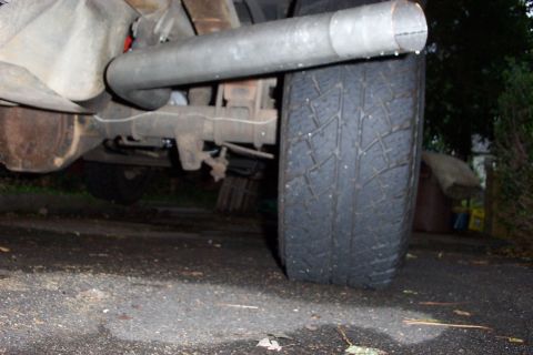 1995 Ford Bronco - Exhaust pipe and tire detail from a vehicle.