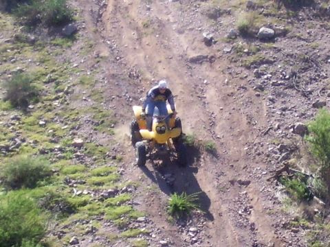 1991 Ford Bronco - Rider on a yellow ATV navigates a dusty, off-road trail.