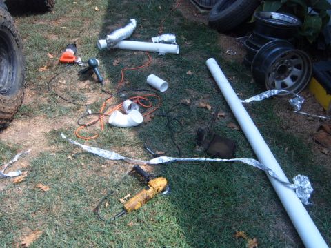 1988 Ford Bronco - Tools and parts laid out on the grass, possibly for a vehicle modification project.
