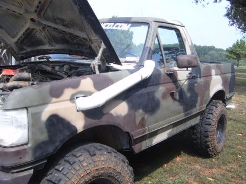 1988 Ford Bronco - This Ford Bronco, painted in camouflage, has its hood up and a snorkel installed.