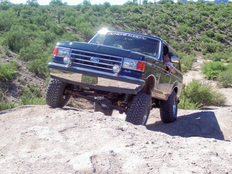 1991 Ford Bronco - This Ford Bronco, likely from the late 1980s, navigates a challenging off-road course with a "NICHE AUDIO" sticker visible on the windshiel…