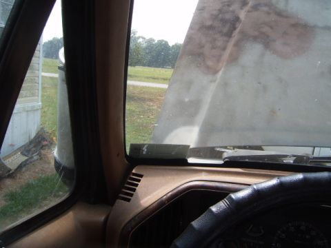 1988 Ford Bronco - View from inside a vehicle, showing the dashboard, steering wheel, and windshield with a sticker.