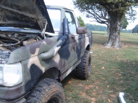 1988 Ford Bronco - This 1988 Ford Bronco features a camouflage paint job and a snorkel intake, with its hood raised.