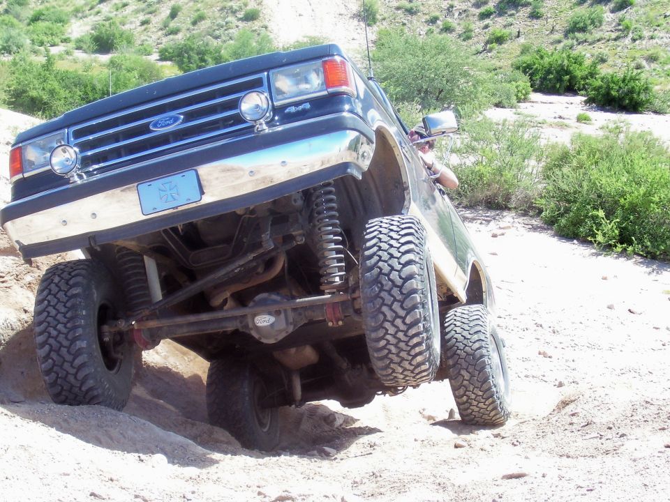 1991 Ford Bronco off-roading, front 3/4 view, dark blue