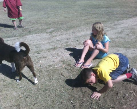 1989 Ford Bronco - Children and a dog are in a field, with one child digging in the dirt.