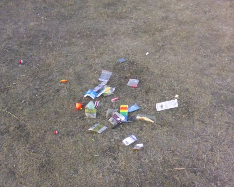 1989 Ford Bronco - Fishing lures and tackle are strewn across the ground, suggesting a campsite or fishing spot.