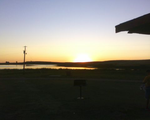 1989 Ford Bronco - Sunset over a lake with a utility pole and a person visible on the right side.