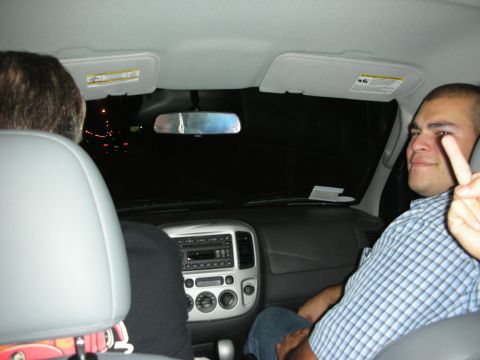 1998 Ford Crown Victoria - Interior view of a car at night with two people inside, one making a peace sign.