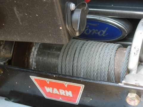 1995 Ford Bronco - Close-up of a WARN winch mounted on a vehicle, with a Ford badge visible.