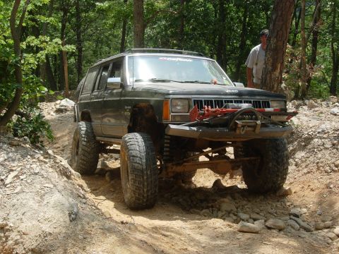 1995 Ford Bronco - A modified Jeep Cherokee navigates a challenging off-road path.