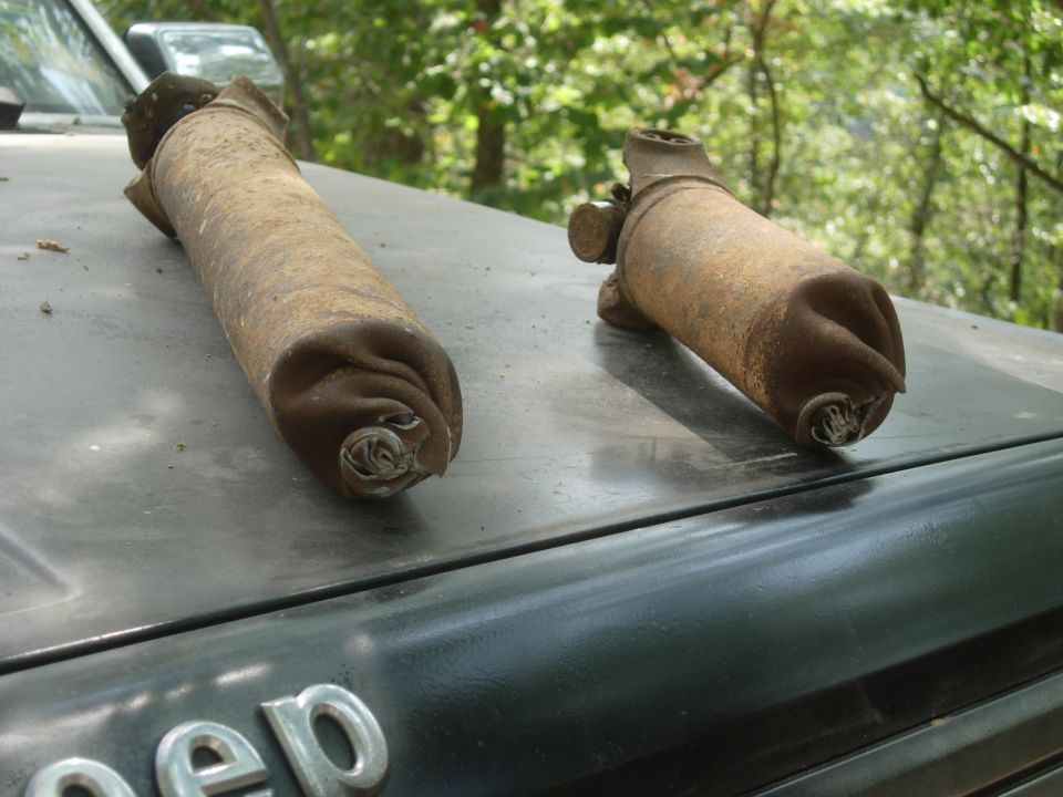 Two rusty exhaust pipes on the hood of a Jeep