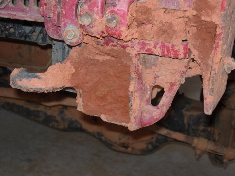 1995 Ford Bronco - Mud-covered metal part, likely from an off-road vehicle, showing signs of heavy use.