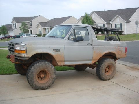 1995 Ford Bronco - This modified Ford Bronco is parked in front of a suburban house.