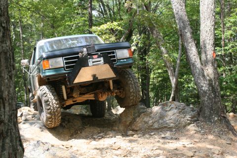 1990 Ford Bronco - Off-road Bronco navigates a rocky trail, demonstrating its capabilities.