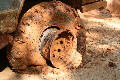 1990 Ford Bronco - This vehicle's wheel and suspension are heavily caked in mud, suggesting it has been driven off-road.