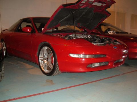 1991 Ford Probe - Front 3/4 view of a red 1991 Ford Probe with its hood open, revealing the engine compartment.