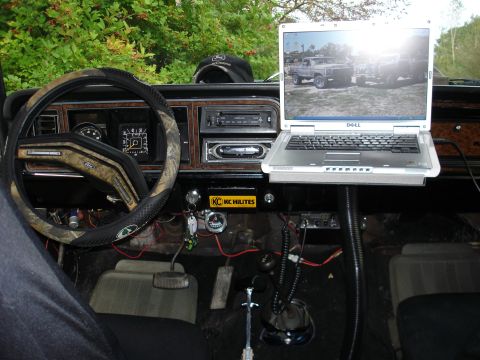 1979 Ford Bronco - The interior of an older vehicle features a laptop mounted to the dashboard, displaying an image of a truck.