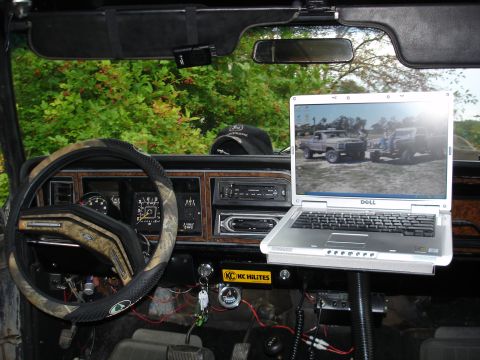 1979 Ford Bronco - The interior of a 1979 Ford Bronco shows a laptop mounted on the dashboard, alongside various gauges and accessories.