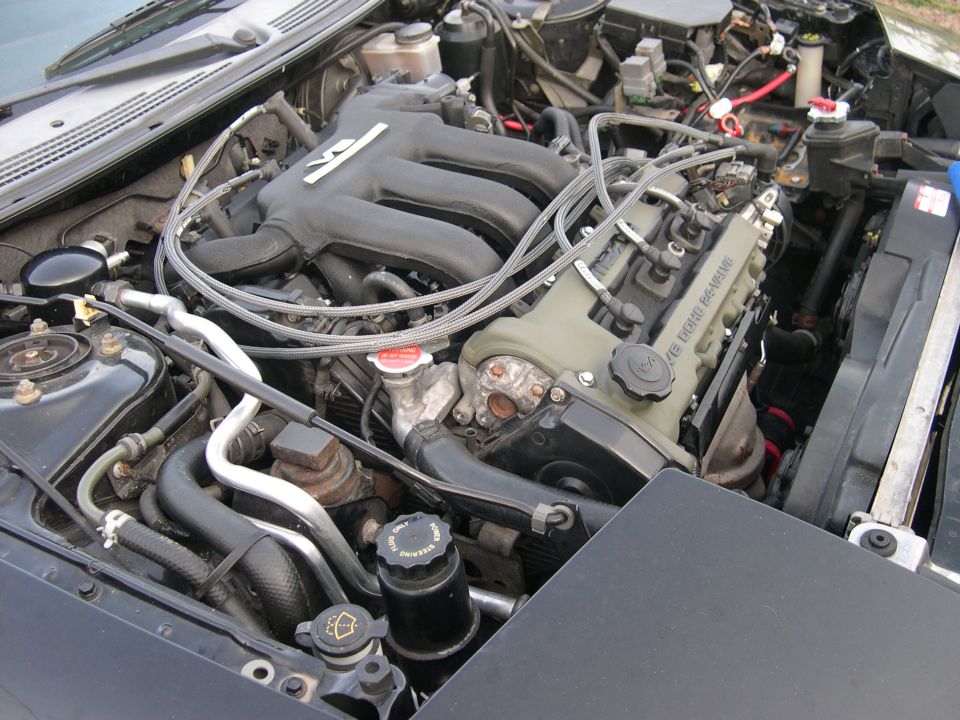 Engine bay of a 1997 Ford Probe, showing the V6 engine with black intake manifold and green valve covers