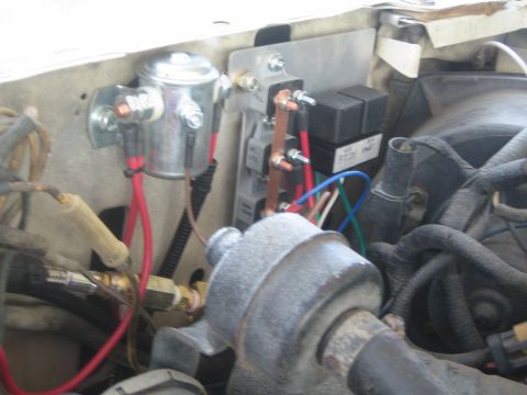1990 Ford Bronco - Engine-bay wiring detail showing a solenoid, relays, copper bus bars and colored wires near the firewall.
