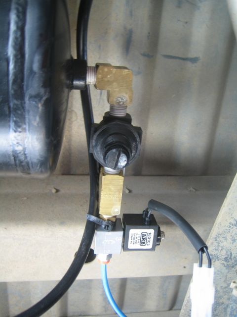 1990 Ford Bronco - brass valve assembly and an ARB-branded solenoid plumbed into a black air tank, mounted under a vehicle frame.