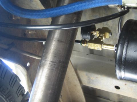 1990 Ford Bronco - Brass push-fit fittings and air lines connected to a black air spring bag mounted alongside a vehicle frame and axle.