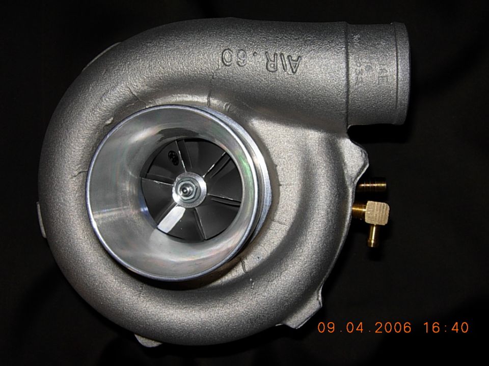 Turbocharger compressor housing with visible compressor wheel and brass fittings, cast 'AIR .60' text.