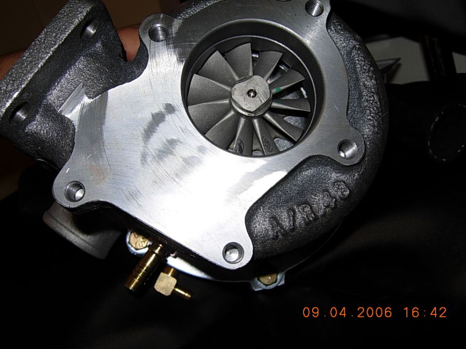 Turbocharger compressor housing with visible wheel and A/R 48 cast marking, held in hand
