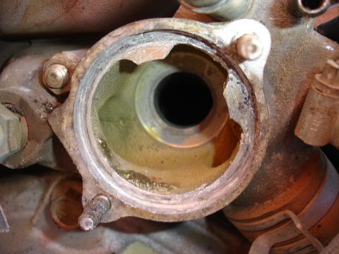 1993 Ford Taurus - This image shows a close-up view of a corroded engine component with a broken flange, likely requiring replacement.