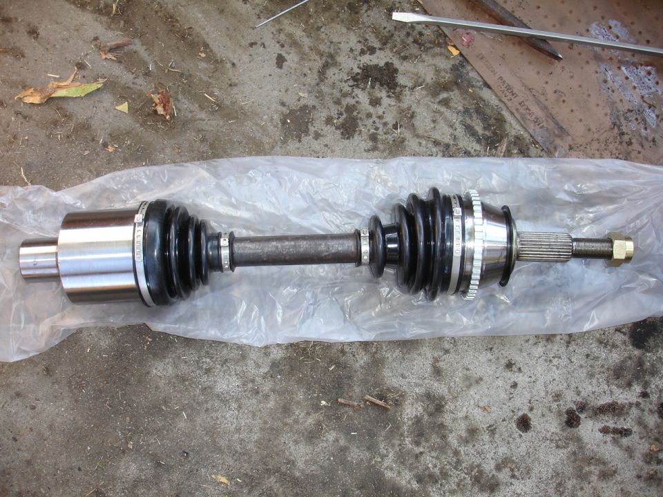 CV axle with rubber boots and metal splines, laid on plastic sheeting