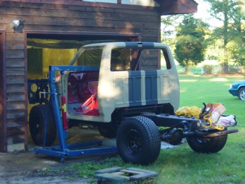1991 Ford Bronco - Chassis reassembly of a 1991 Ford Bronco, with an engine hoist positioned to assist.