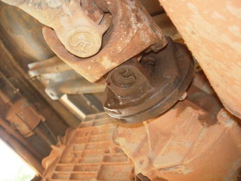 1995 Ford Bronco - Underside view of a vehicle's drivetrain components, focusing on the U-joint and transmission.